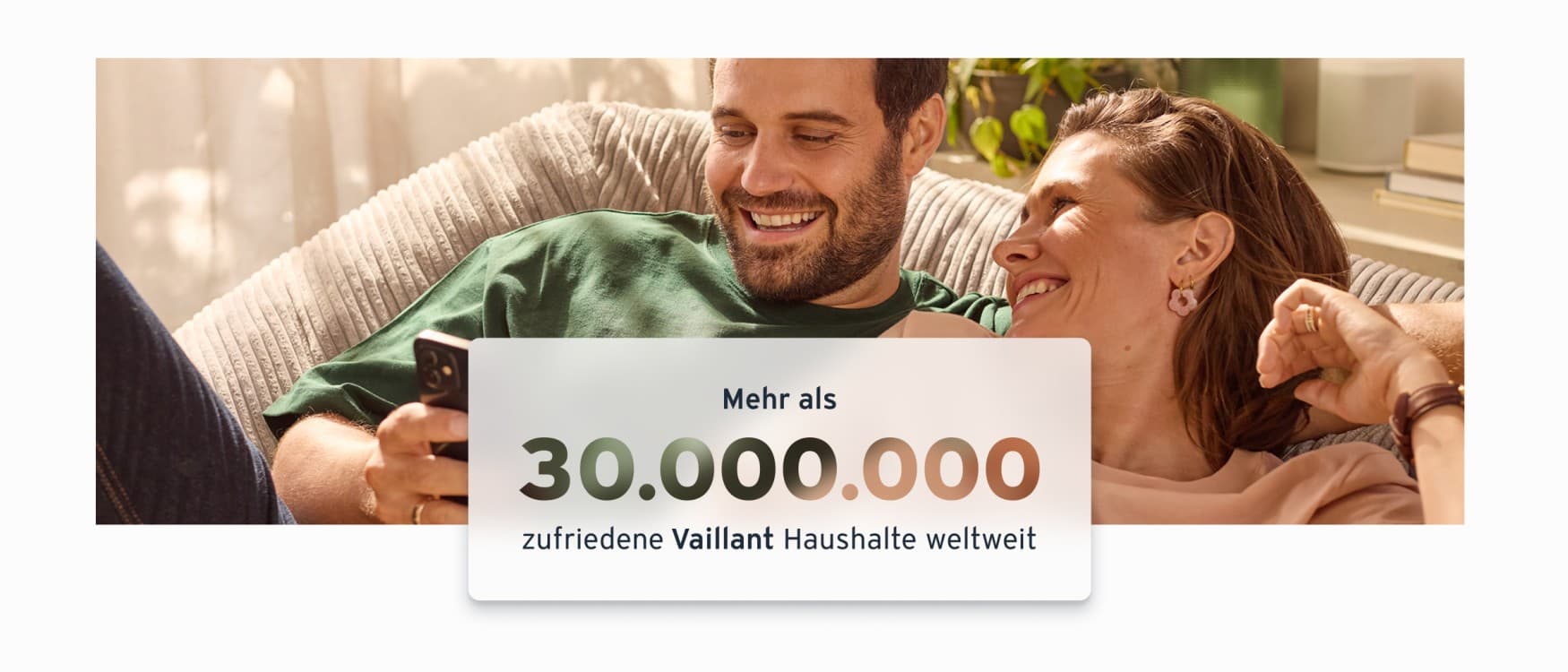 Ein Paar sitzt Arm in Arm auf einem gemütlichen Sofa. Davor ist eine Textbox eingeblendet mit dem Inhalt: Mehr als 30.000.000 zufriedene Vaillant Haushalte weltweit.
