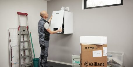 Ein Fachhandwerker entfernt die Abdeckung von einem Vaillant Gast-Brennwertgerät