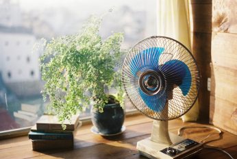 Ein Ventilator steht auf einem Fensterbrett, die Sonne scheint in den Raum