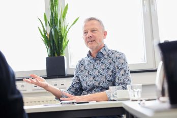 Rainer Haase sitzt im Büro und wird interviewt.