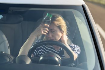 Frau im Auto sucht Kühlung