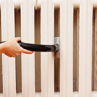 Person, die den Heizkörper absaugt