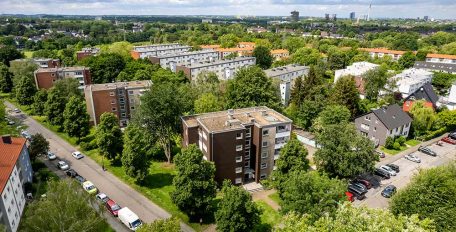 Das Bild zeigt aus der Vogelperspektive eine Wohnsiedlung aus den 60er und 70er Jahren mit zahlreichen Hochhäusern und Geschosswohnungsbauten.