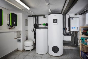 Im Heizungskeller eines Einfamilienhauses steht ein Warmwasserspeicher, der von einer Luft/Wasser-Wärmepumpe versorgt wird.