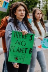 Eine junge Aktivistin hält ein grünes Schild mit der Aufschrift "There is no Planet B" in ihren Händen