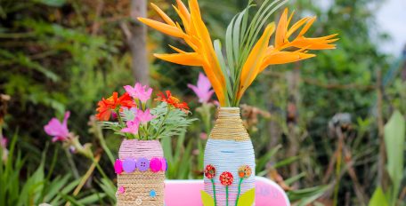 Selbstgemachte Vasen aus alten Materialien mit bunten Blumen