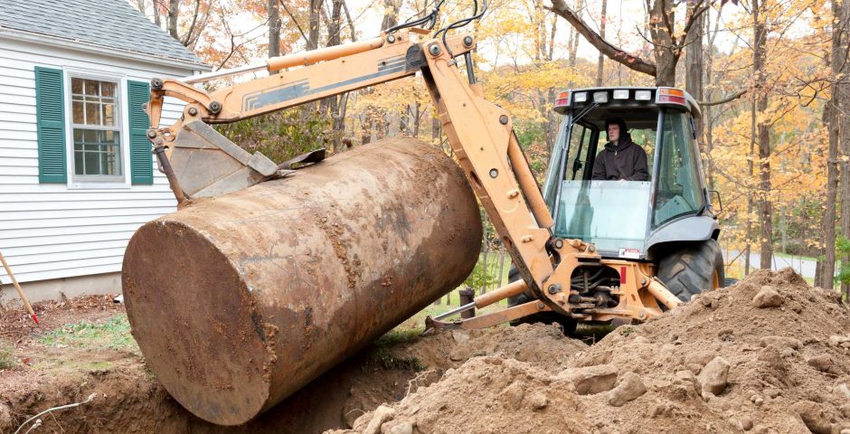 Bagger, der einen alten Öl-Tank aus dem Boden zieht
