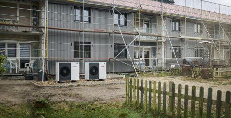 Zwei Wärmepumpen Vaillant aroTHERM plus stehen vor einem sich in der Sanierung befindlichen Reihenhaus
