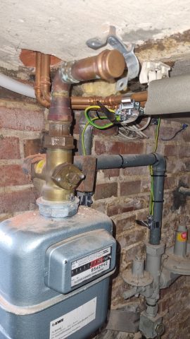 Das Bild zeigt einen außer Betrieb gesetzten Gaszähler in einem alten Keller