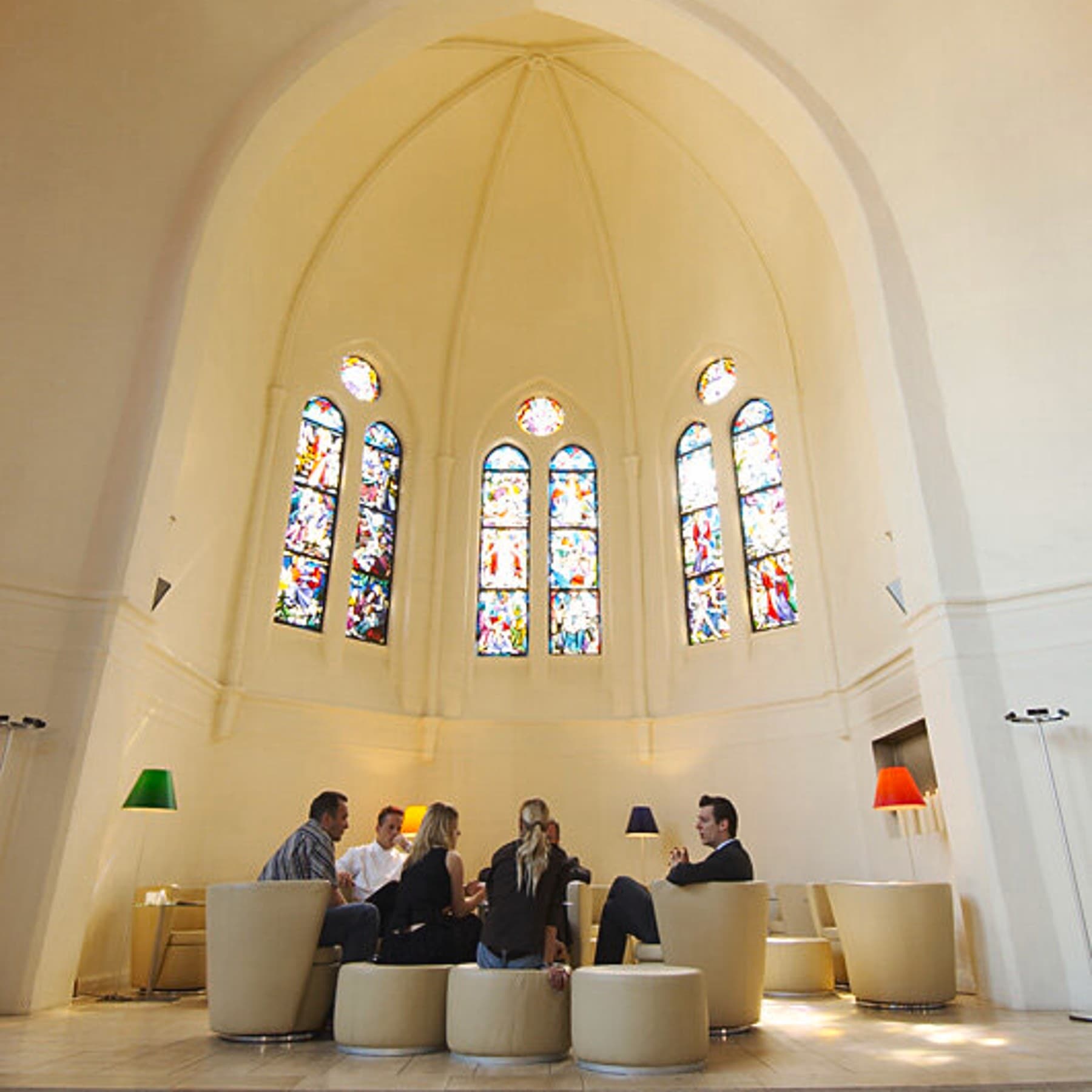 Mehrere Personen sitzen auf Sesseln in der Kirche und unterhalten sich
