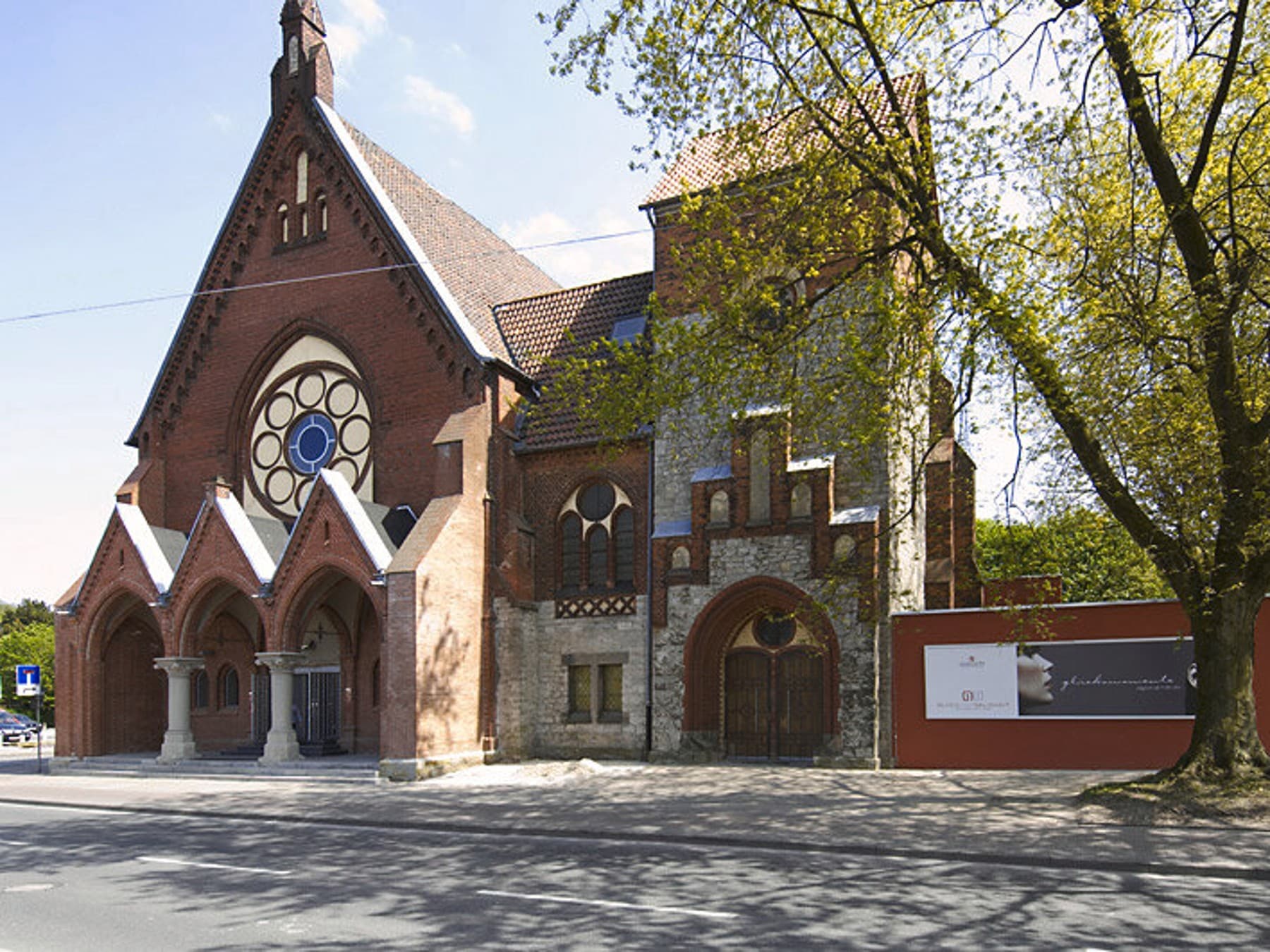 Außenansicht der Martini Kirche vor blauem Himmel, Baum rechts neben der Kirch