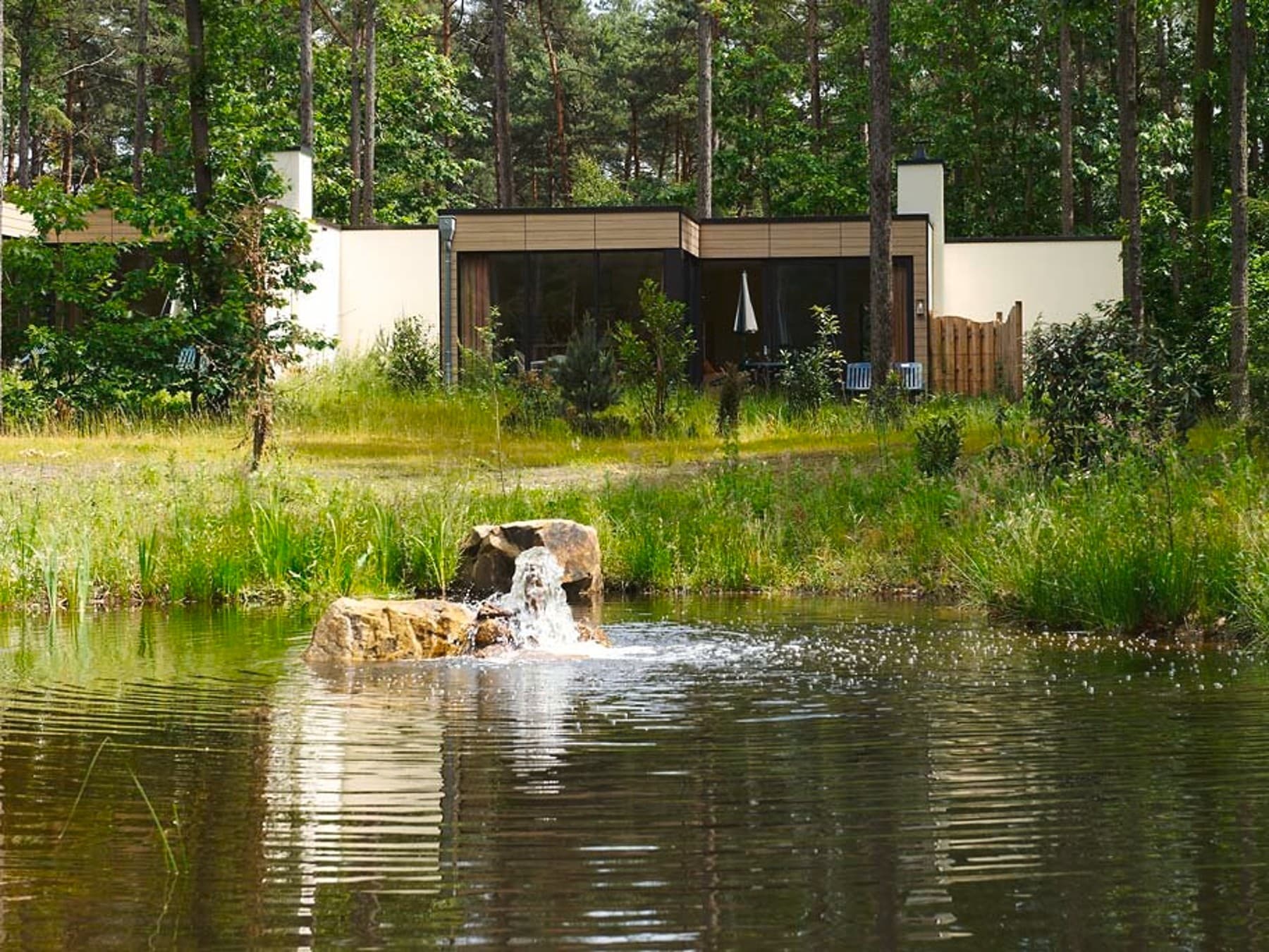 Außenansicht eines Ferienhauses mit einem Teich im Vordergrund