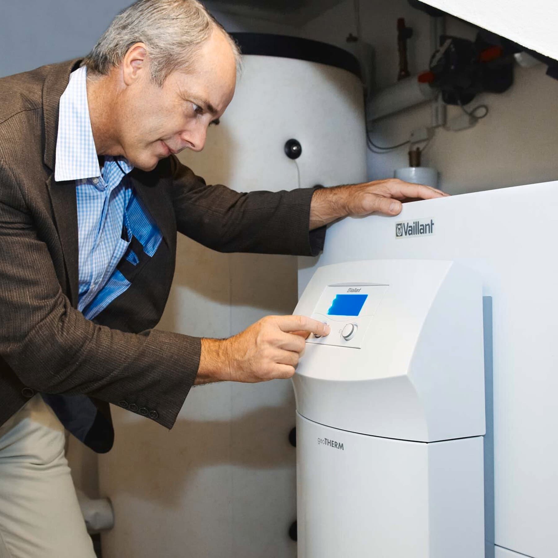 Mann, der über das Display die Vaillant Erdwärmepumpe geoTHERM bedient
