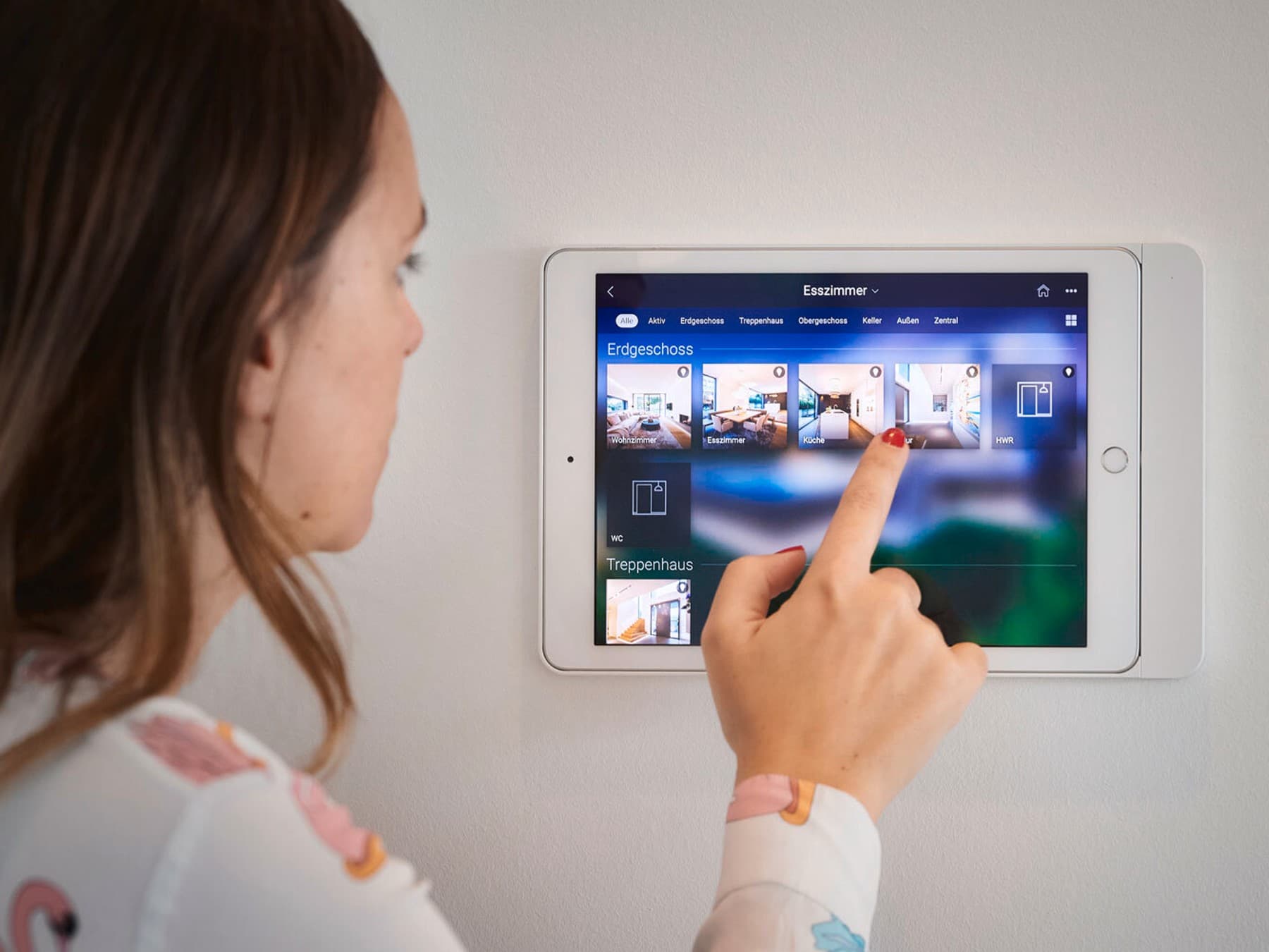Eine Frau, die ein Tablet an der Hauswand bedient