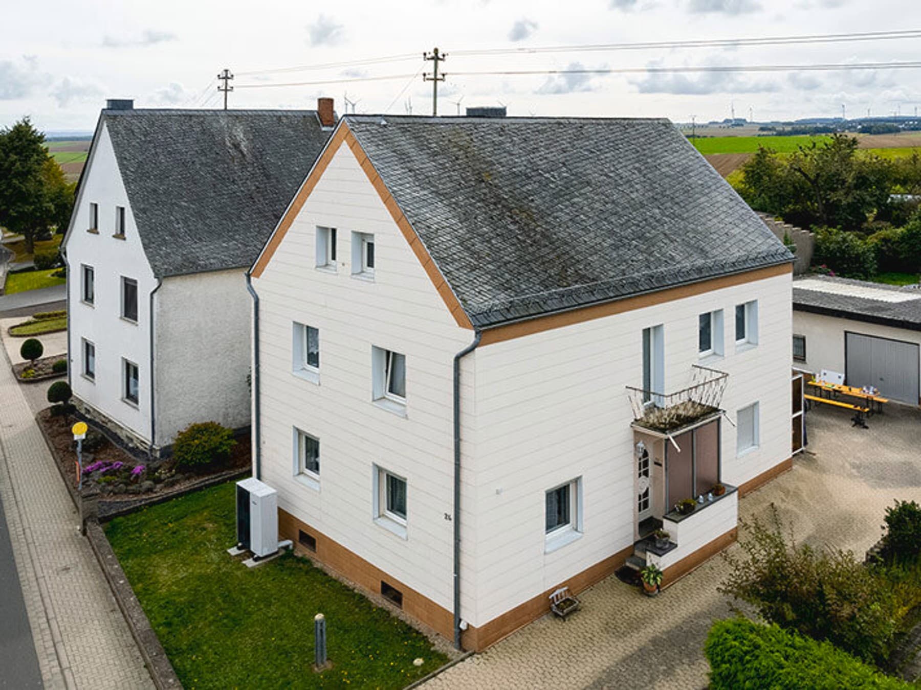Luftaufnahme vom Einfamilienhaus mit Wärmepumpe im Vorgarten