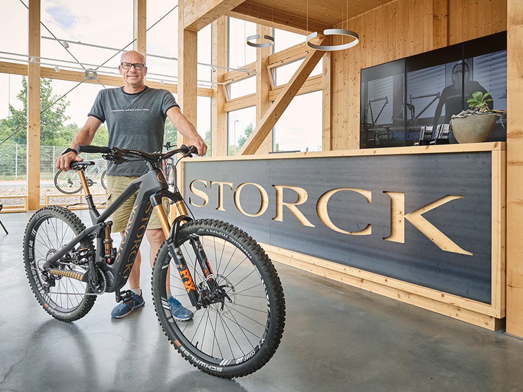 Besitzer der Manufaktur steht mit einem Fahrrad vor dem Tresen