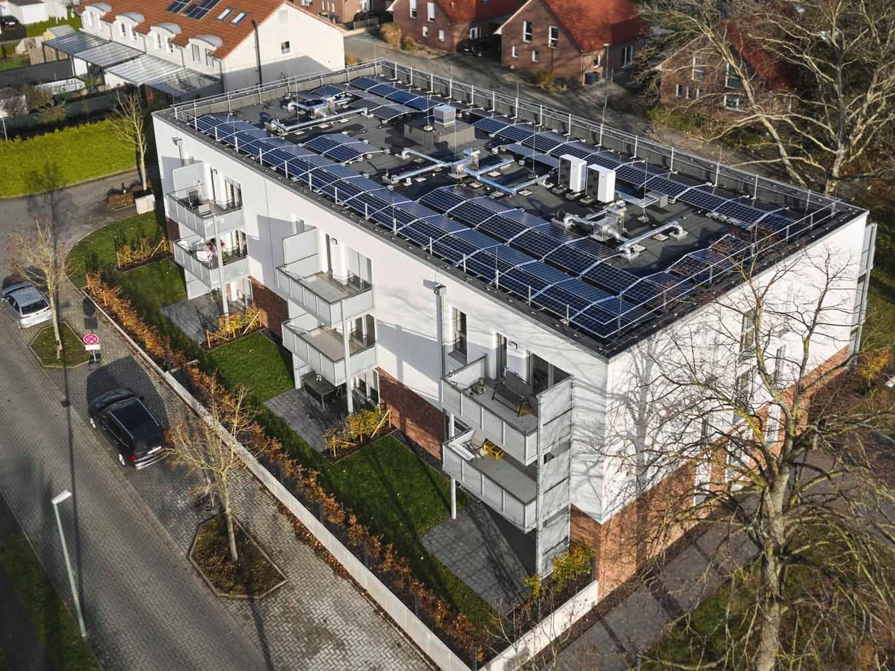 Blick aus der Vogelperspektive auf das Mehrfamilienhaus mit Photovoltaik auf dem Dach