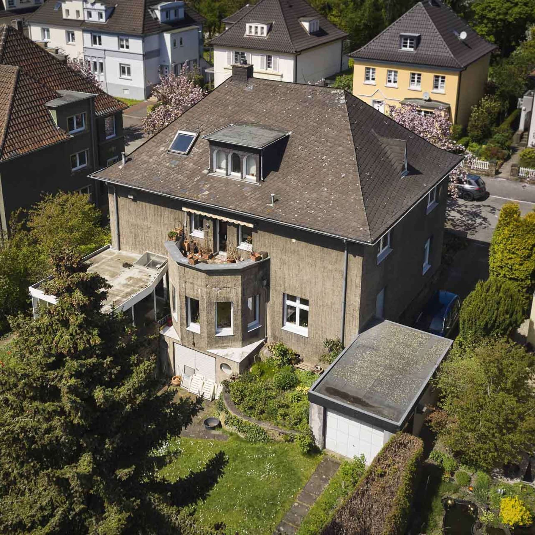 Alte Stadtvilla aus Vogelperspektive, im Hintergrund blühende Kirschbäume