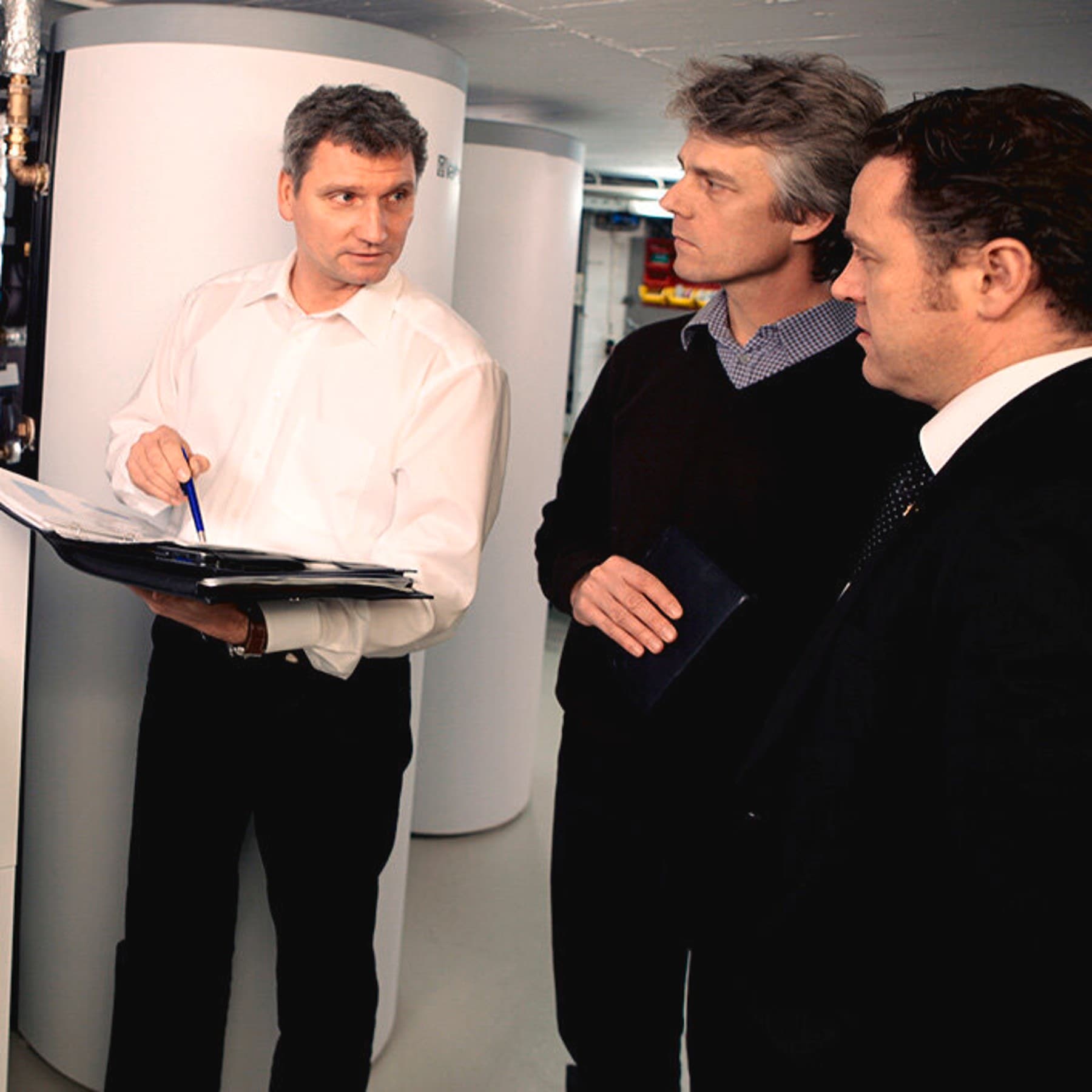 Mehrere Personen im Heizungsraum vor den Vaillant Geräten