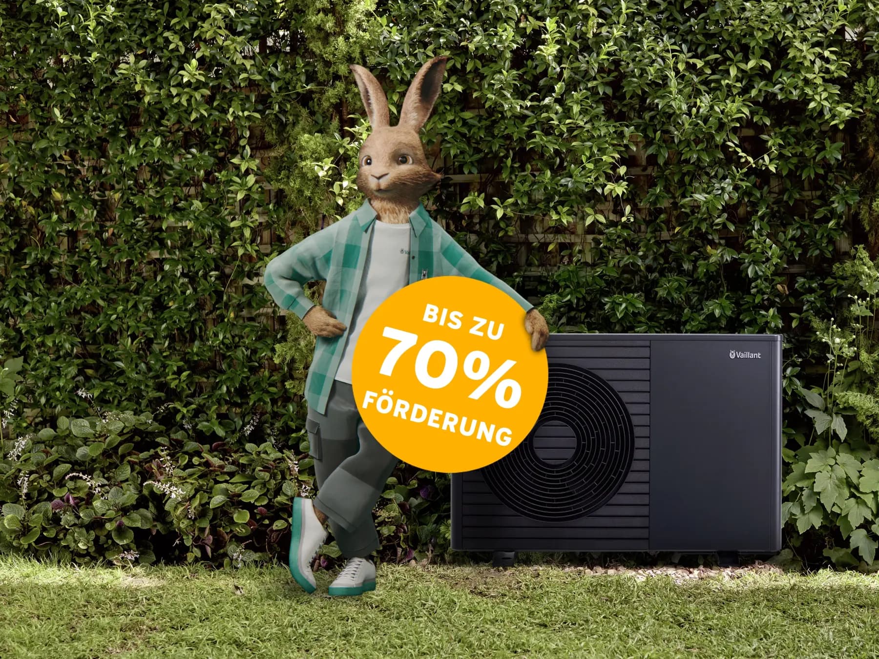 Der Vaillant Hase lehnt an einer Vaillant Wärmepumpe, die auf einer Wiese vor einer Hecke steht. Davor ist eine gelbe Bubble eingeblendet, auf der steht: bis zu 70% Förderung