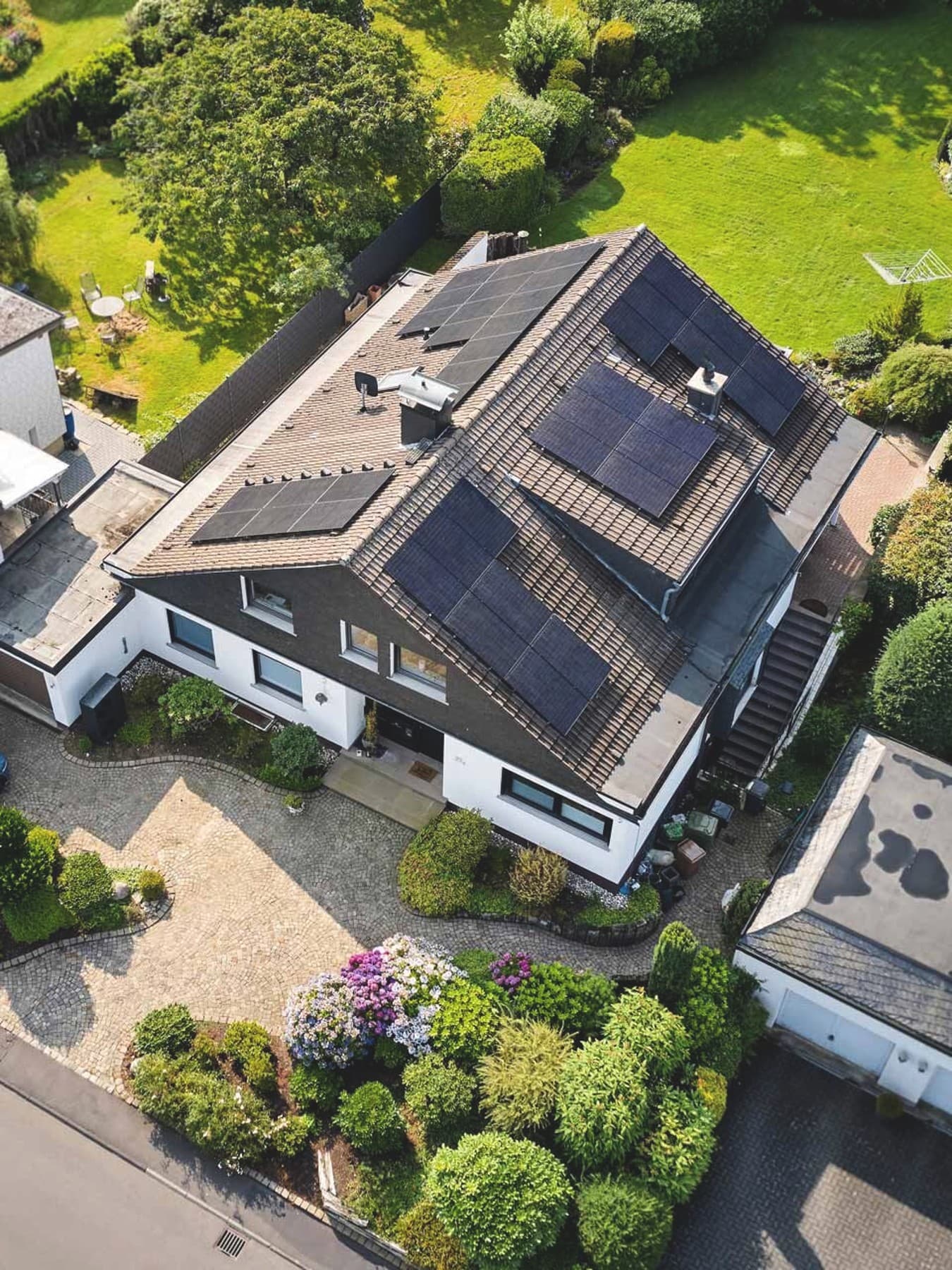 Ein Drohnenbild zeigt die PV Anlage auf einem Hausdach bei einem freistehenden Einfamilienhaus