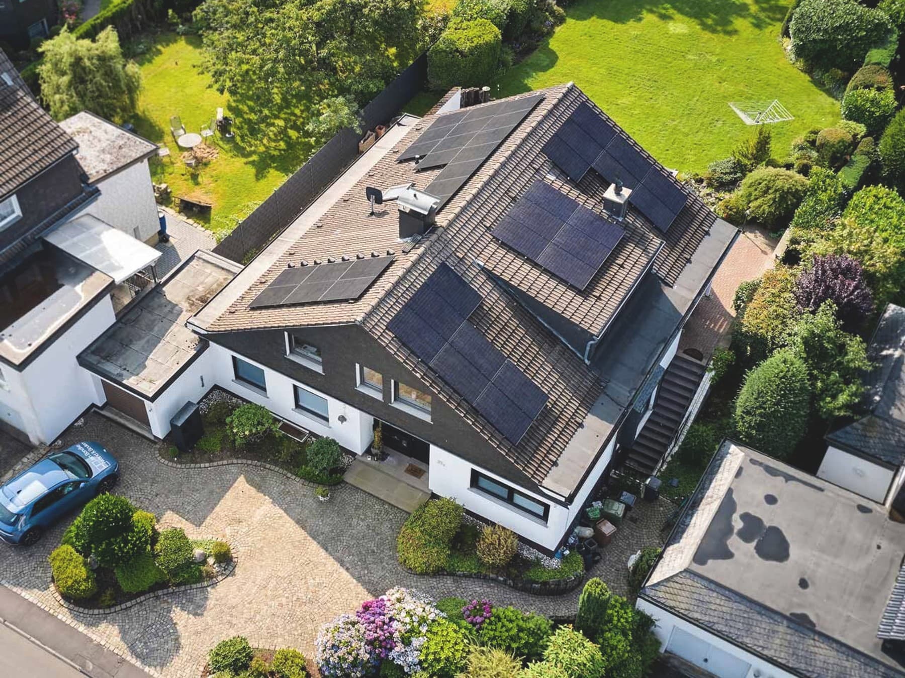 Ein Drohnenbild zeigt die PV Anlage auf einem Hausdach bei einem freistehenden Einfamilienhaus