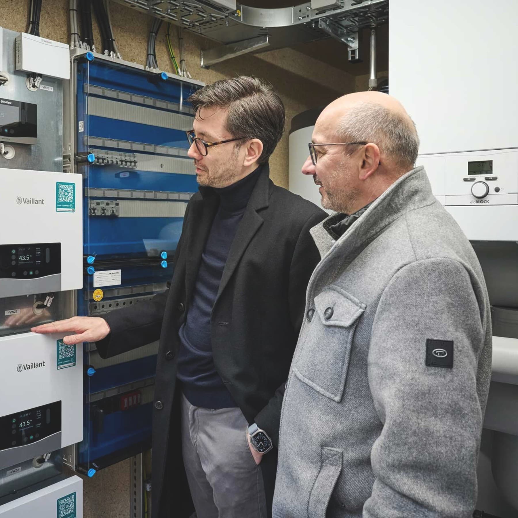 Innenansicht eines Technikcontainers der Energy Unit mit mehreren Steuerungsmodulen von Vaillant, Hydraulikrohren und Verteilern der Wärmepumpenanlage.