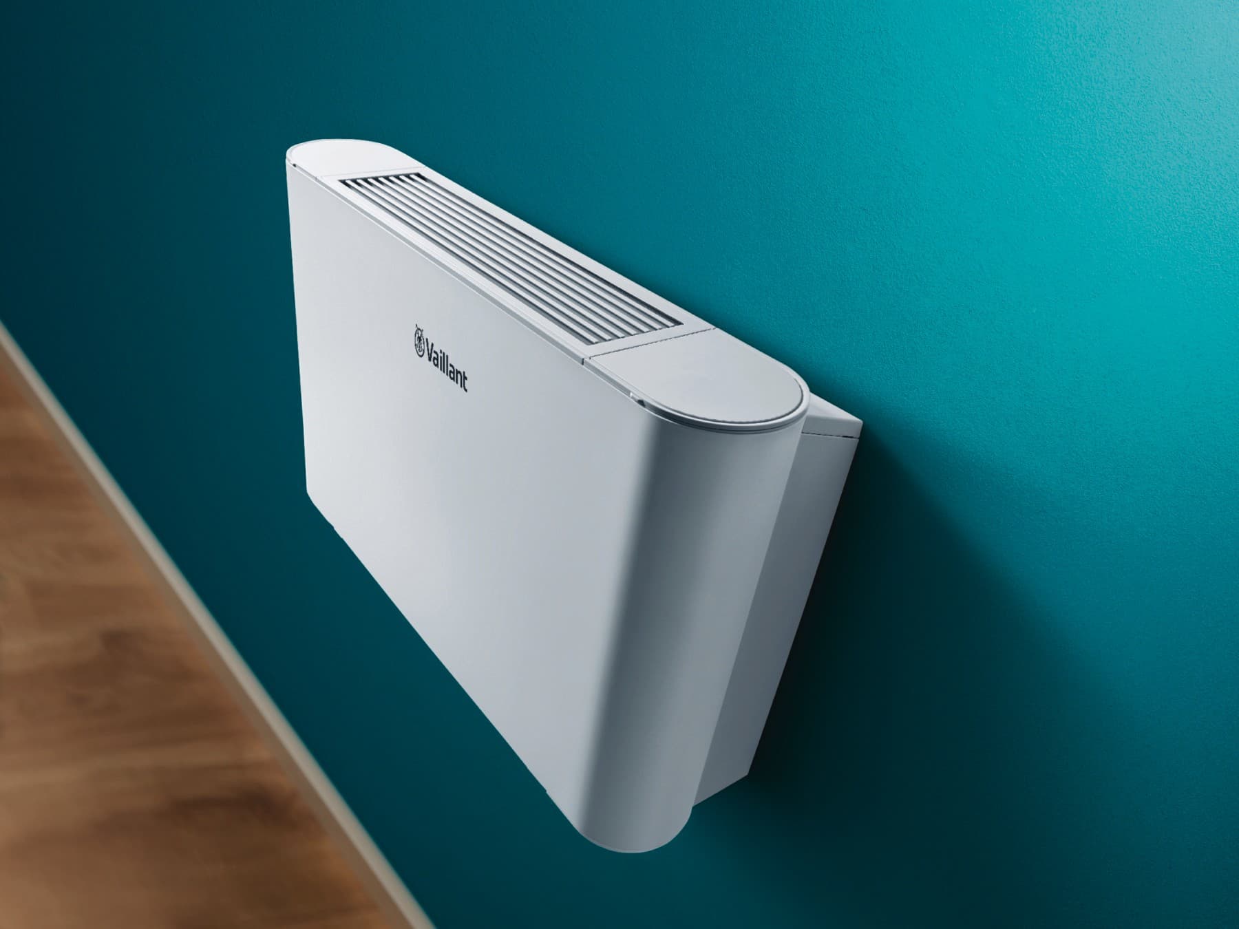 Ein Vaillant Gebläsekonvektor hängt an einer grünen Wand.
