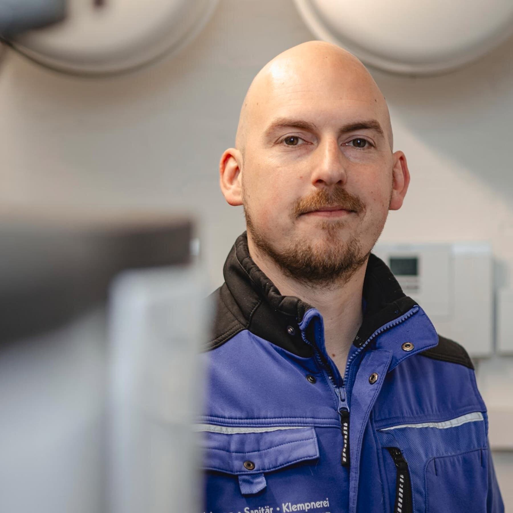 Portraitfoto des Fachhandwerkers im Heizungskeller