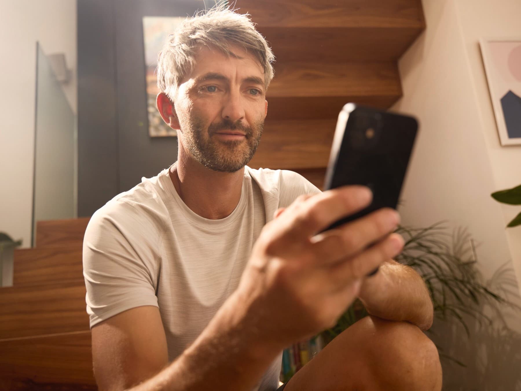 Mann, der auf ein Smartphone in seiner Hand schaut