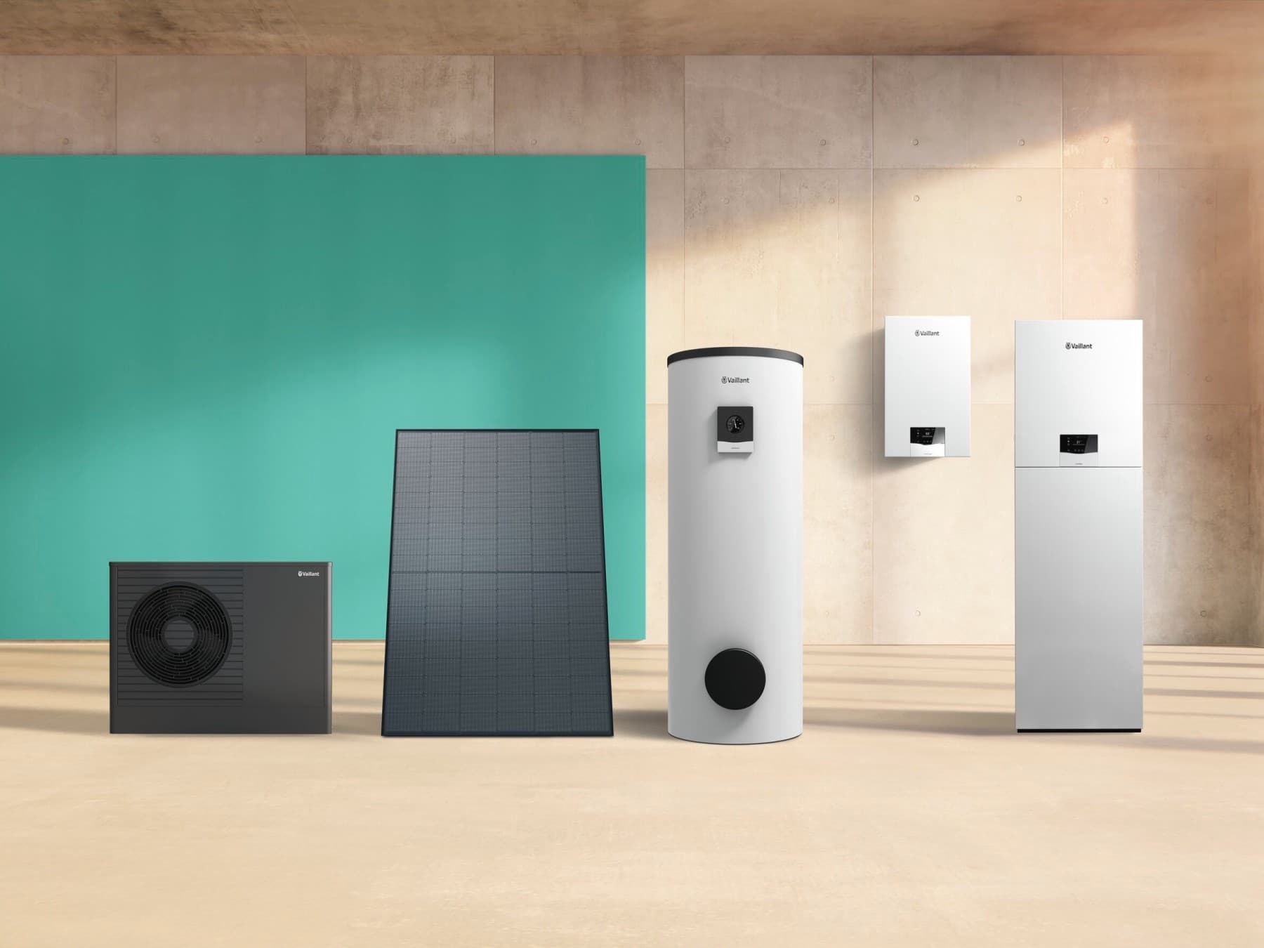 Mehrere Vaillant Geräte, darunter Wärmepumpen, Gasheizungen und ein Solarkollektor sind nebeneinander aufgereiht vor einer grünen Wand.