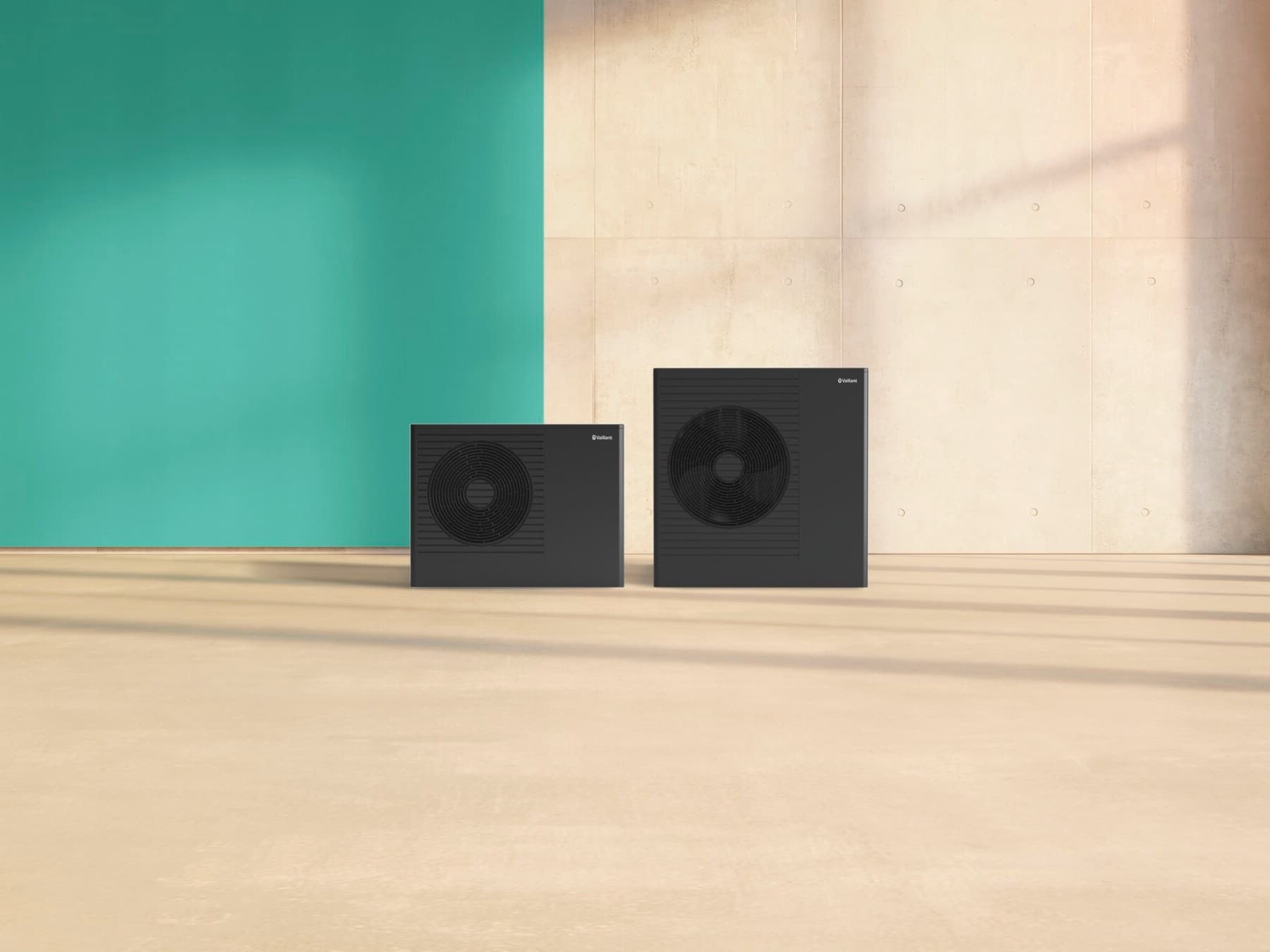 Zwei Vaillant Wärmepumpen der Serie aroTHERM pro in unterschiedlichen Größen stehen nebeneinander vor einem grünen und beigen Hintergrund.