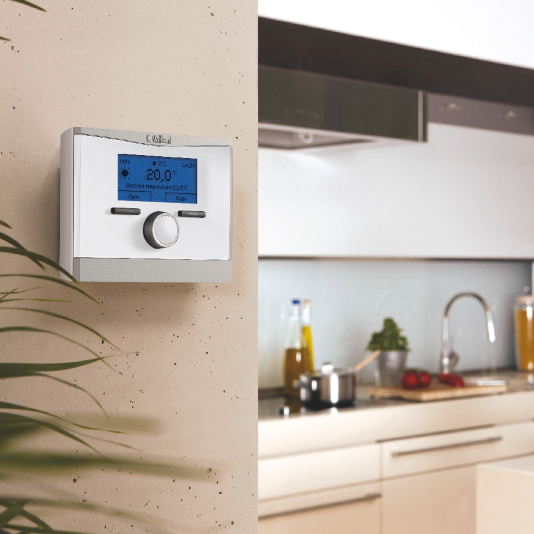 Ein Regler für eine Vaillant Heizung hängt an einer Wand neben der Küchenzeile