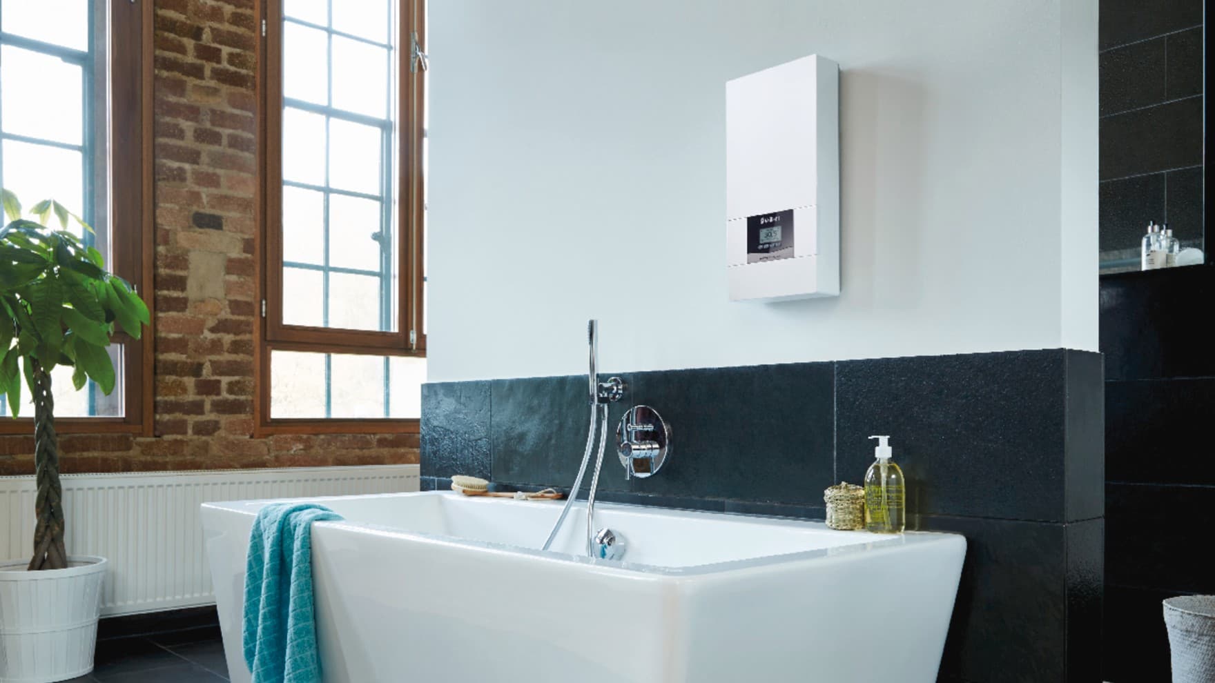 Ein Vaillant Durchlauferhitzer hängt in einem Badezimmer über einer Badewanne.