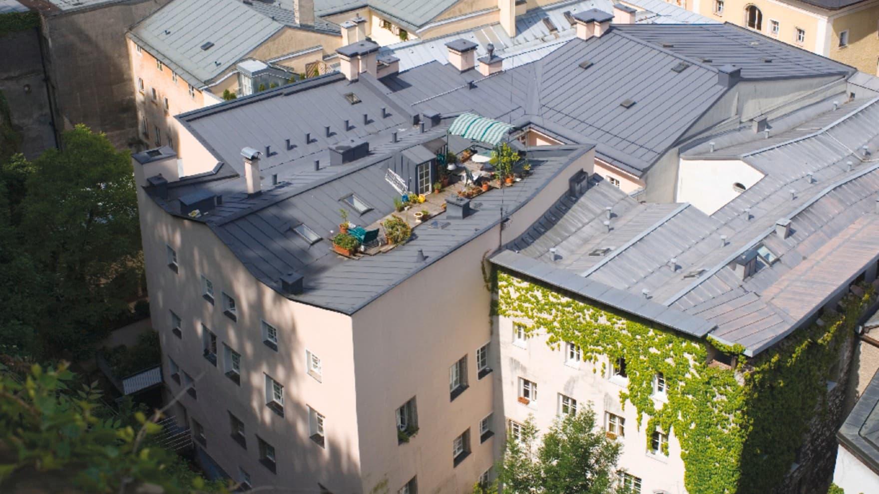 Blick aus der Vogelperspektive auf die Dächer mehrerer Mehrfamilienhäuser