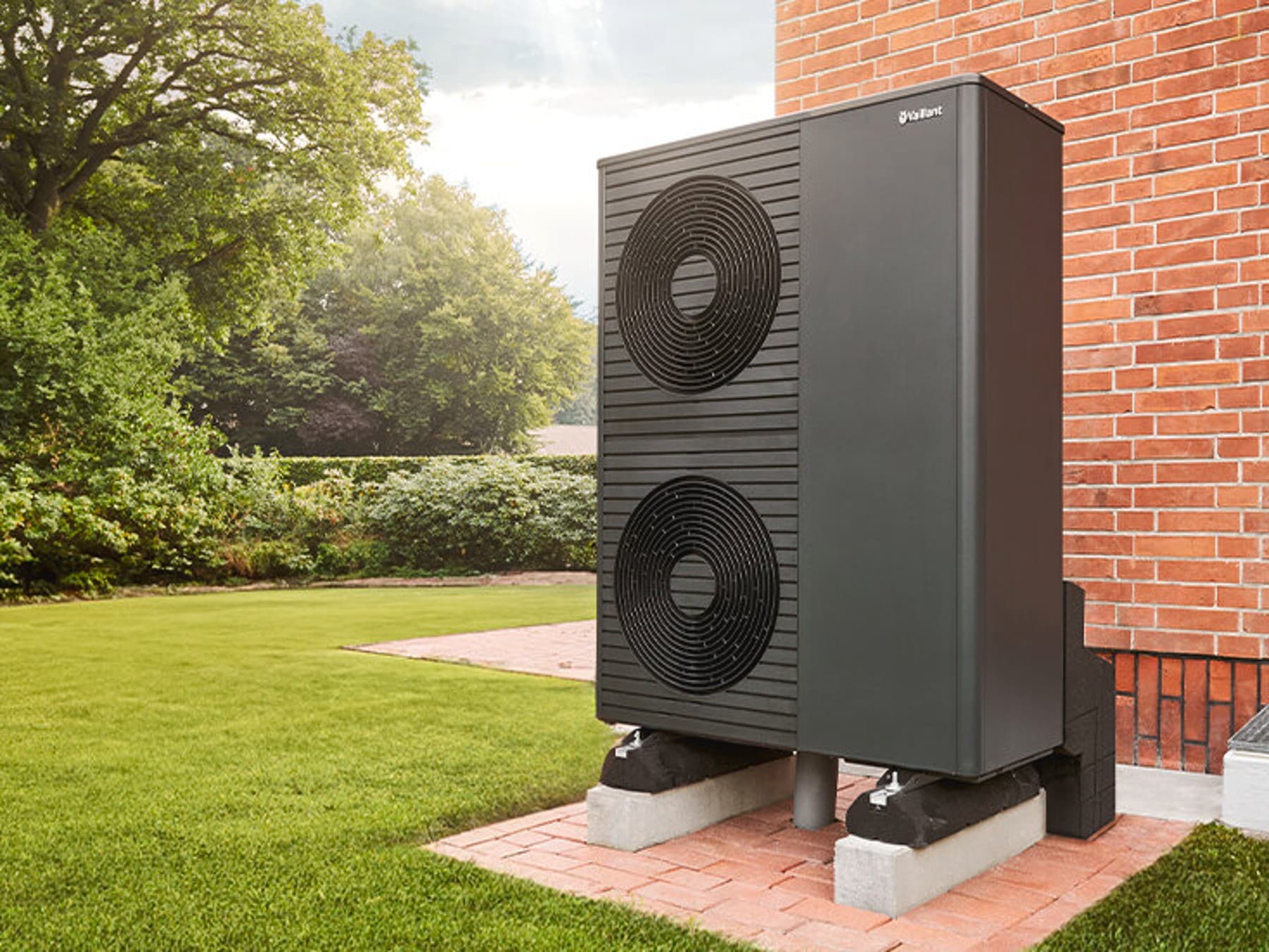 Die aroTHERM plus Wärmepumpe von Vaillant vor einem Backsteinhaus.