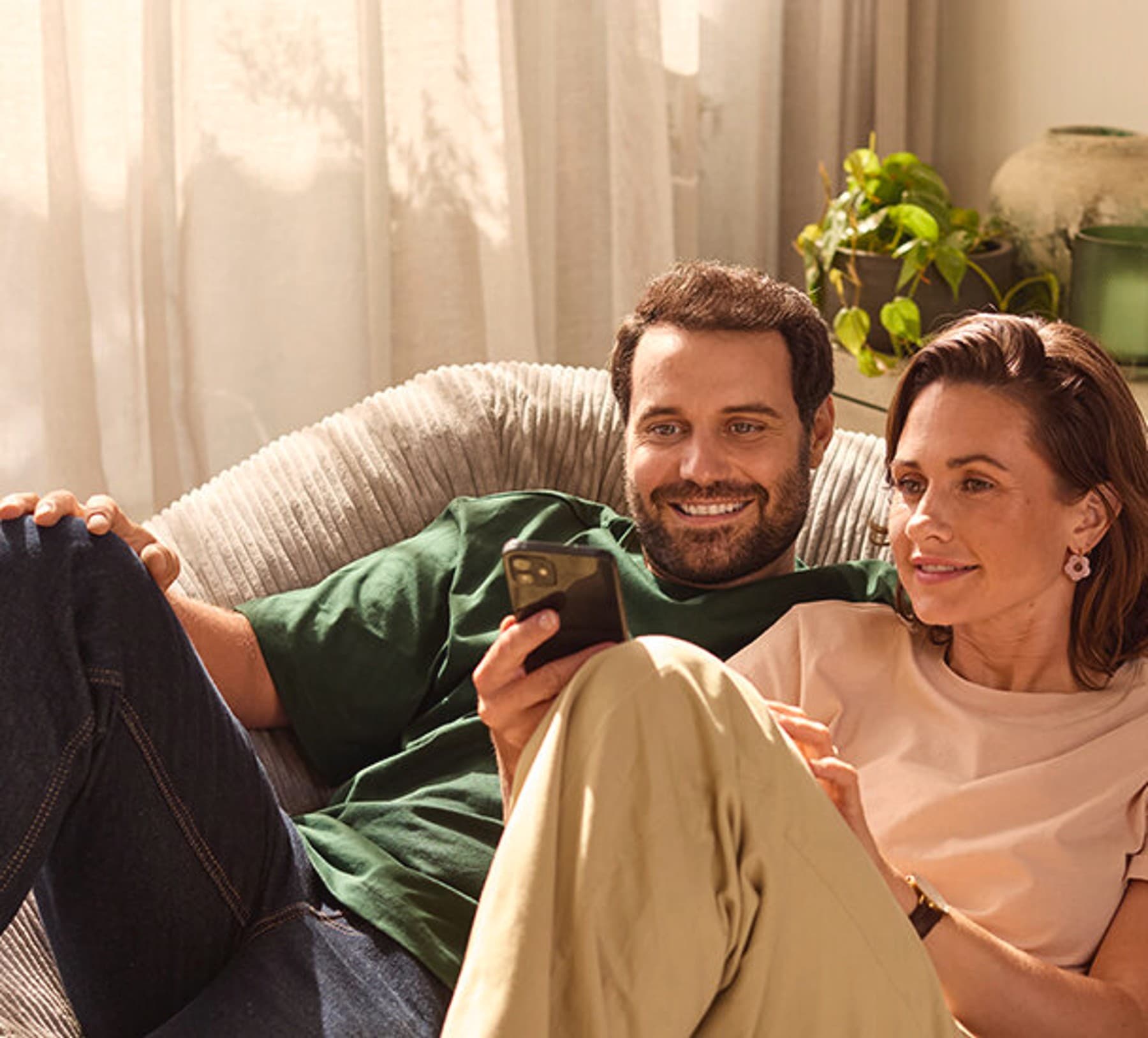 Ein Mann und eine Frau, die sich auf einem Smartphone informieren.