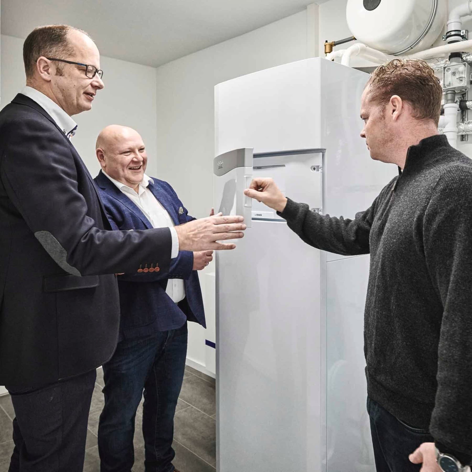 Drei Personen im Heizungsraum vor einem Vaillant Gerät