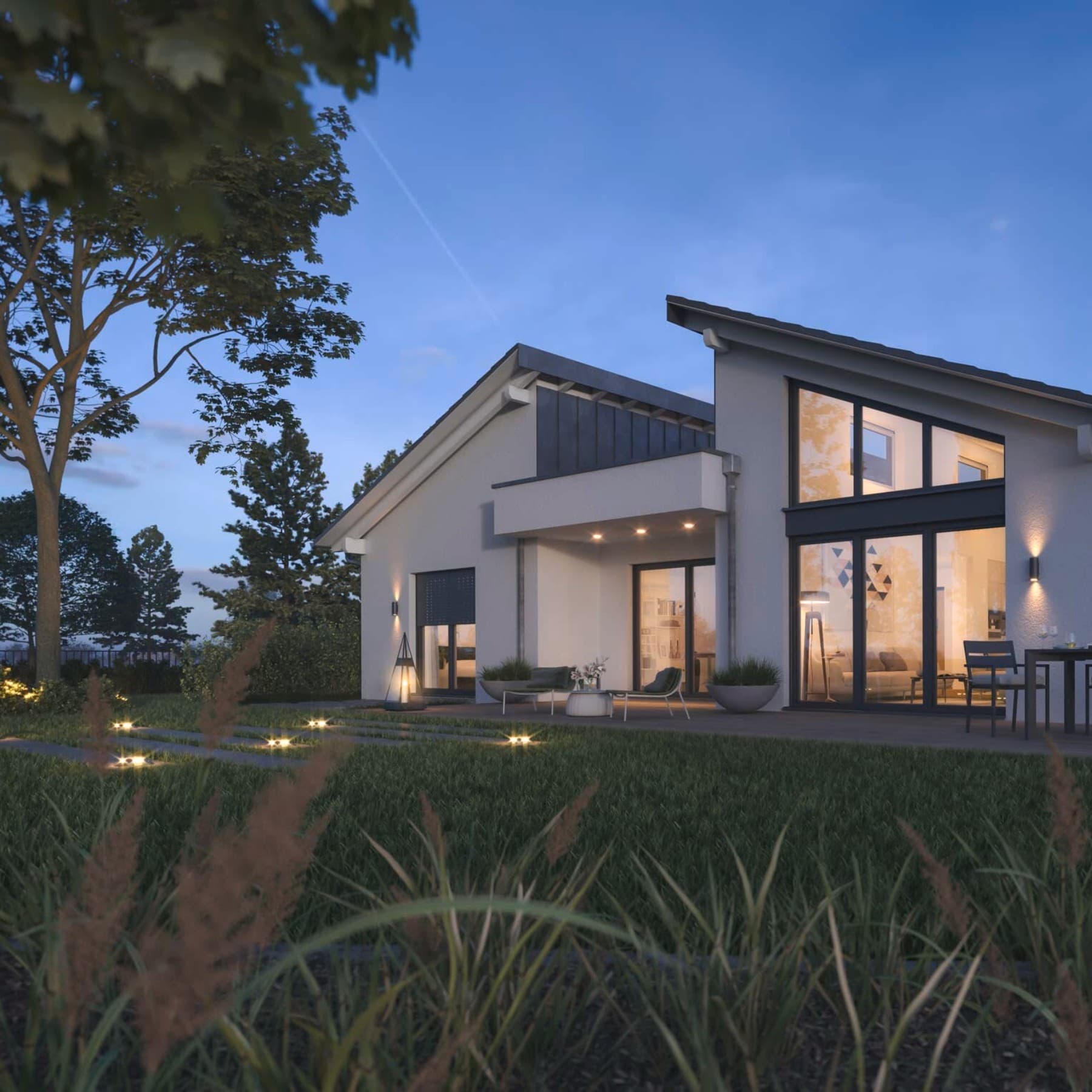 Rückansicht des Bungalows bei Dämmerung mit Garten und Terrasse