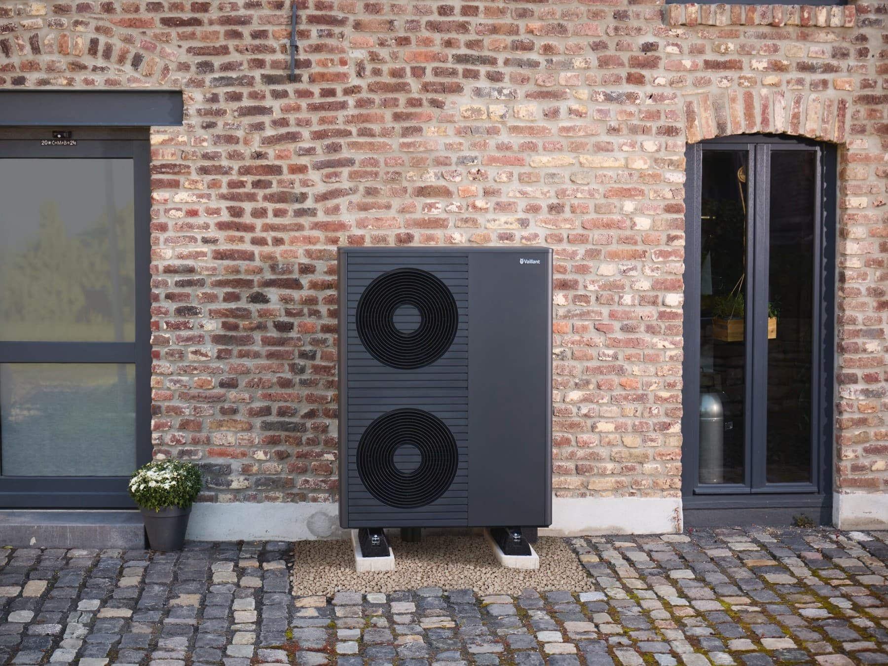 Schwarzgraue Vaillant Wärmepumpe vor einer Hauswand