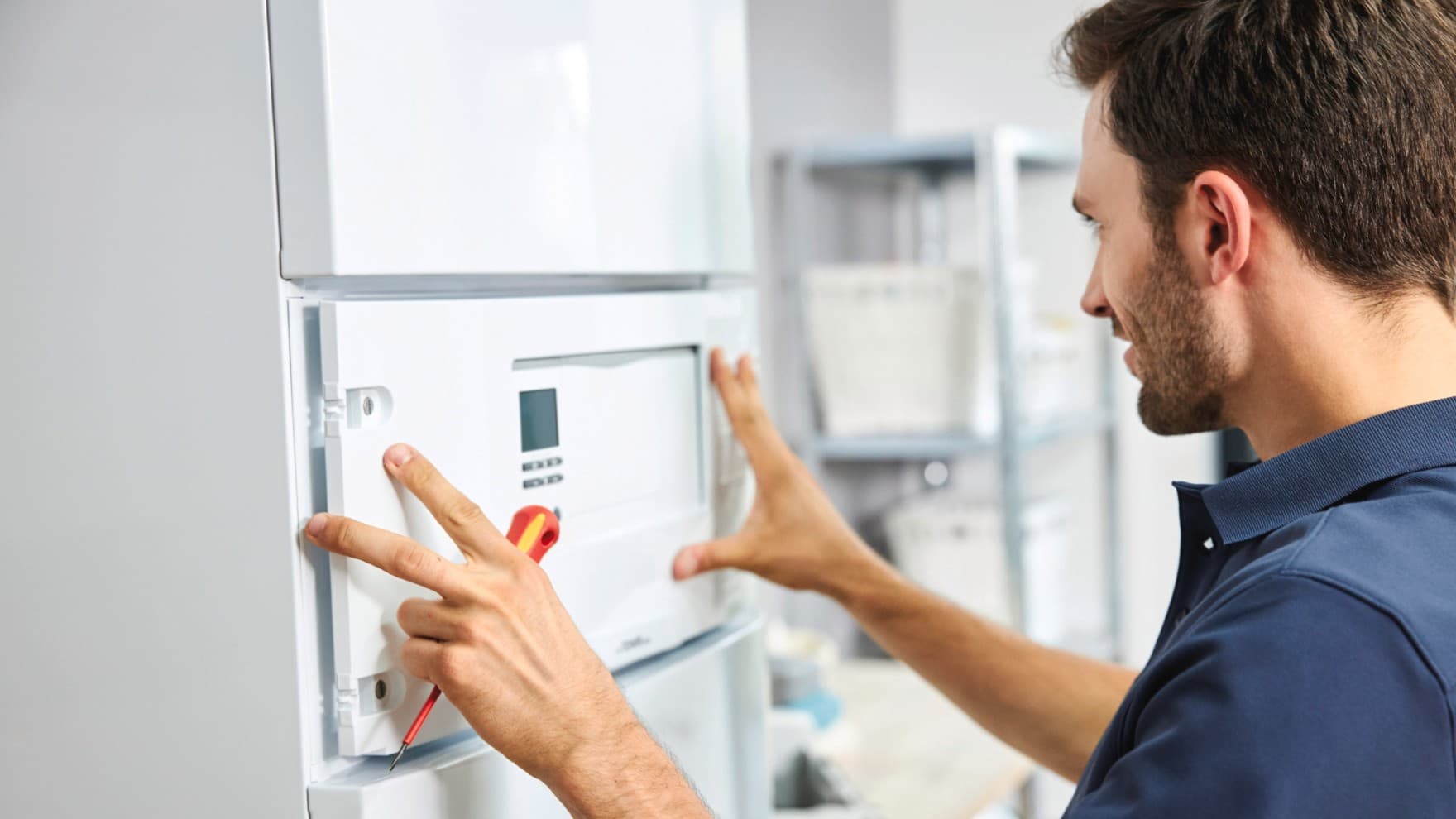 Ein Mann baut den uniTOWER plus ein, der zu einem Wärmepumpen-Heiz-System von Vaillant gehört.