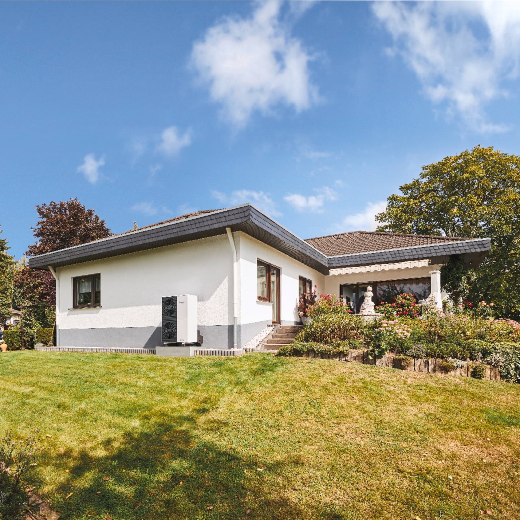 Außenansicht Einfamilienhaus mit Wärmepumpe