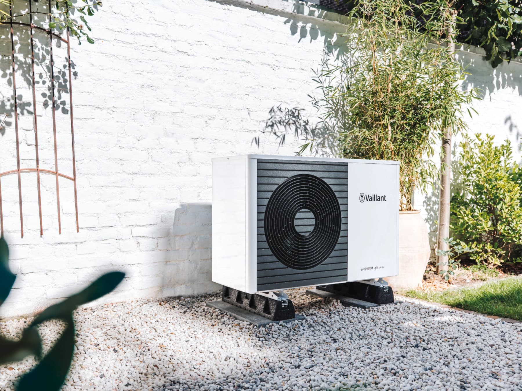 Wärmepumpe aroTHERM Split plus von Vaillant vor einer Gartenmauer.