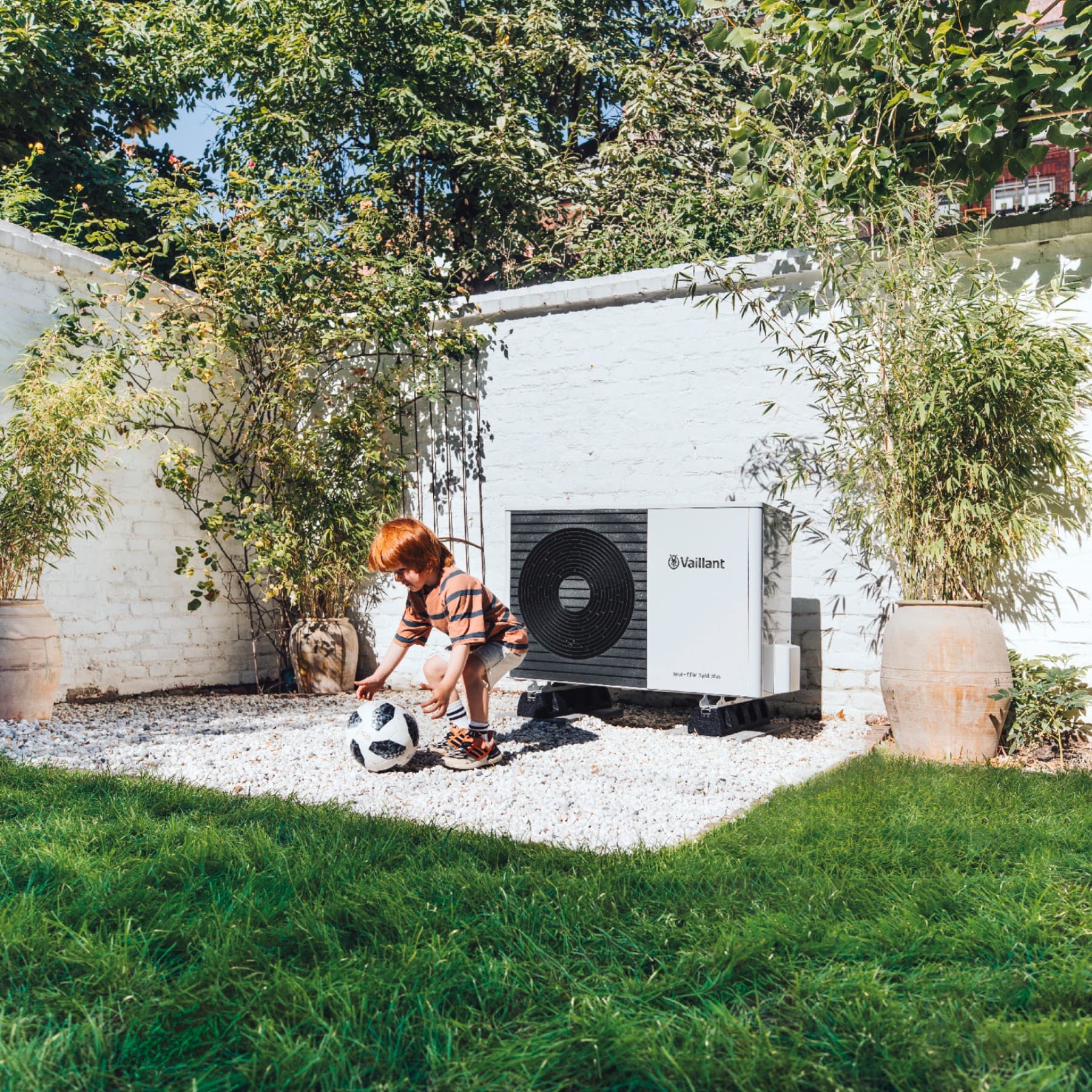Spielendes Kind vor einer Vaillant Wärmepumpe