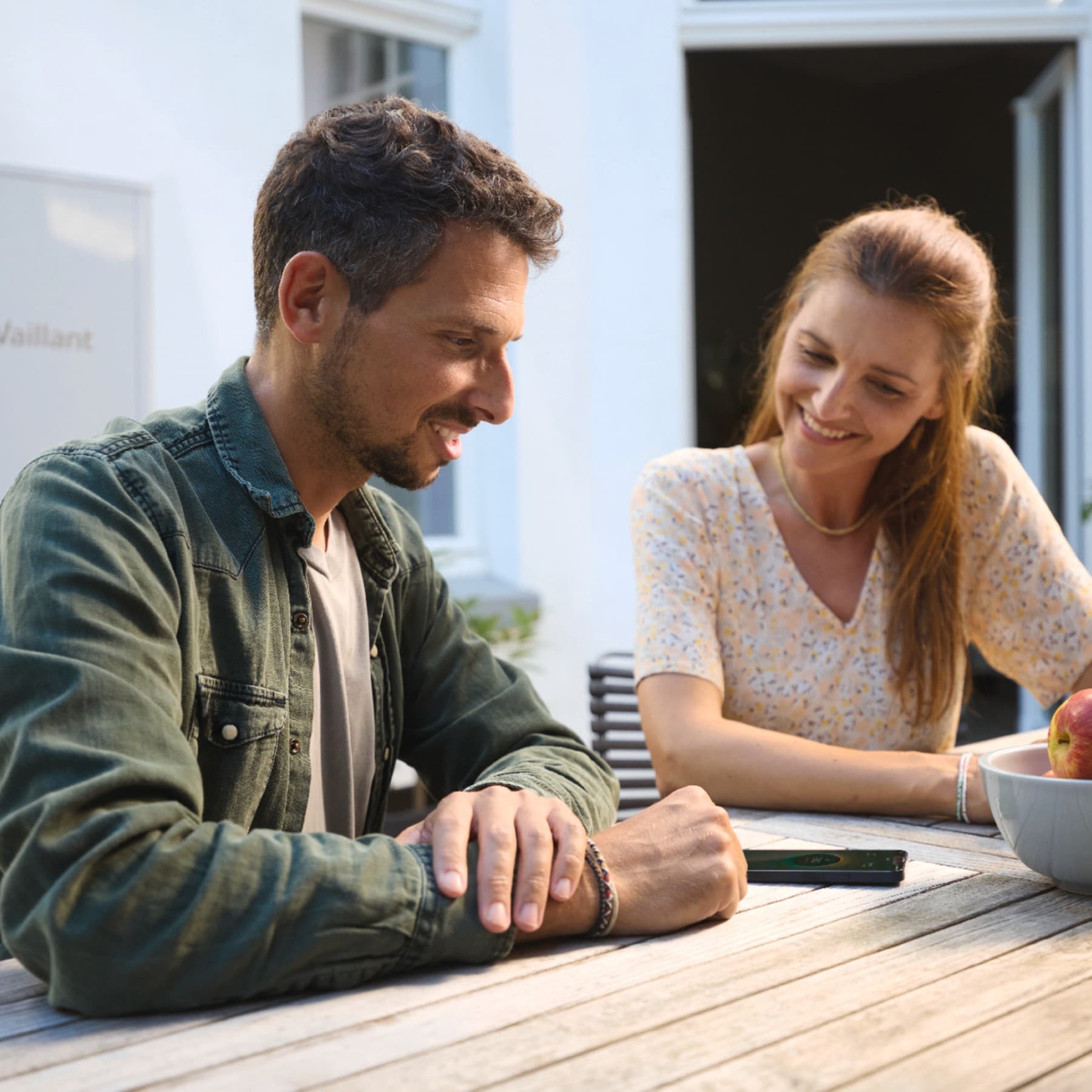 Ein Pärchen an einem Tisch mit einem Smartphone in der Mitte