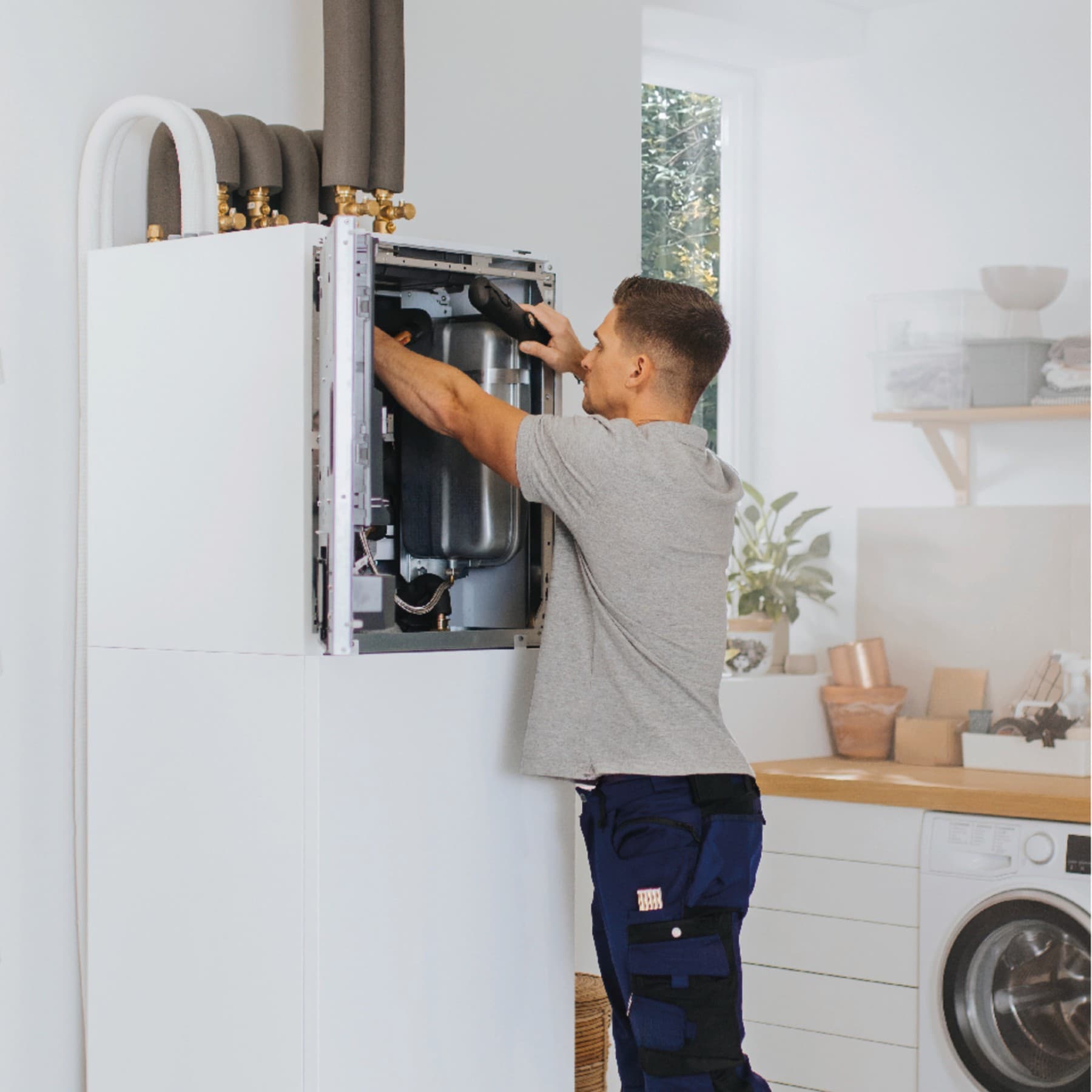 Fachhandwerker bei der Installation an einer Inneneinheit einer Wärmepumpe
