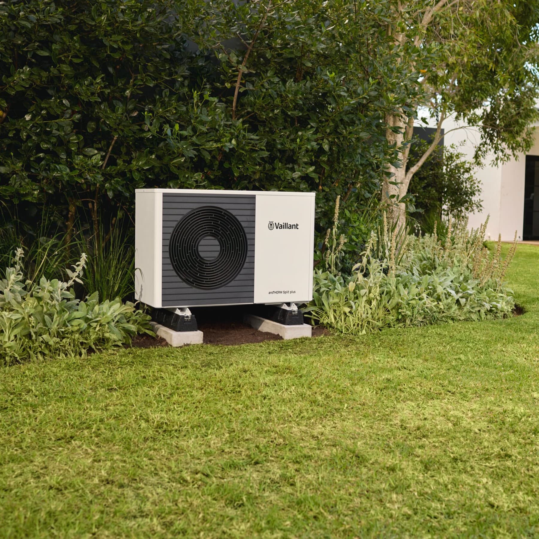 Eine Außeneinheit einer Wärmepumpe im Garten
