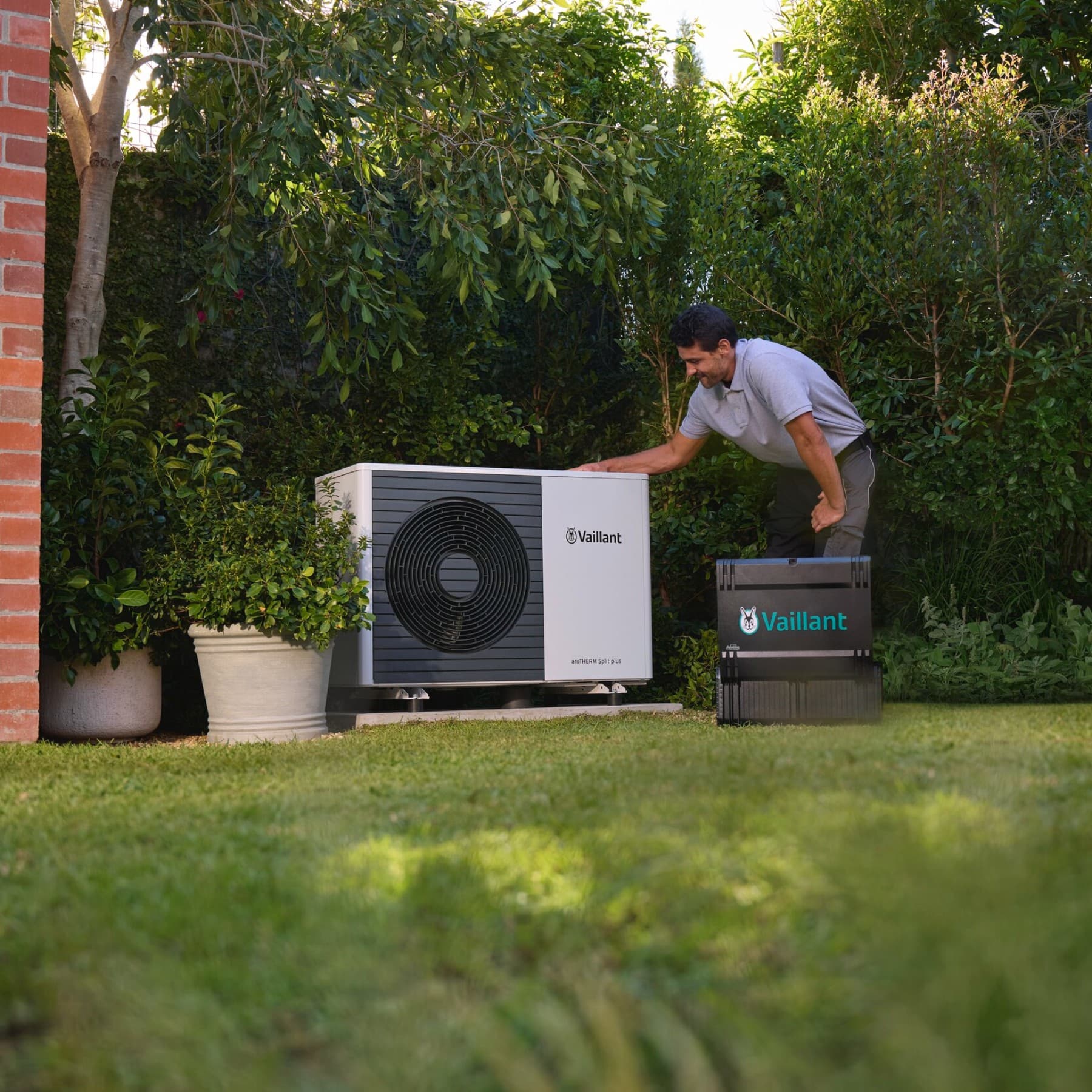 Fachhandwerker installiert Wärmepumpe im Garten