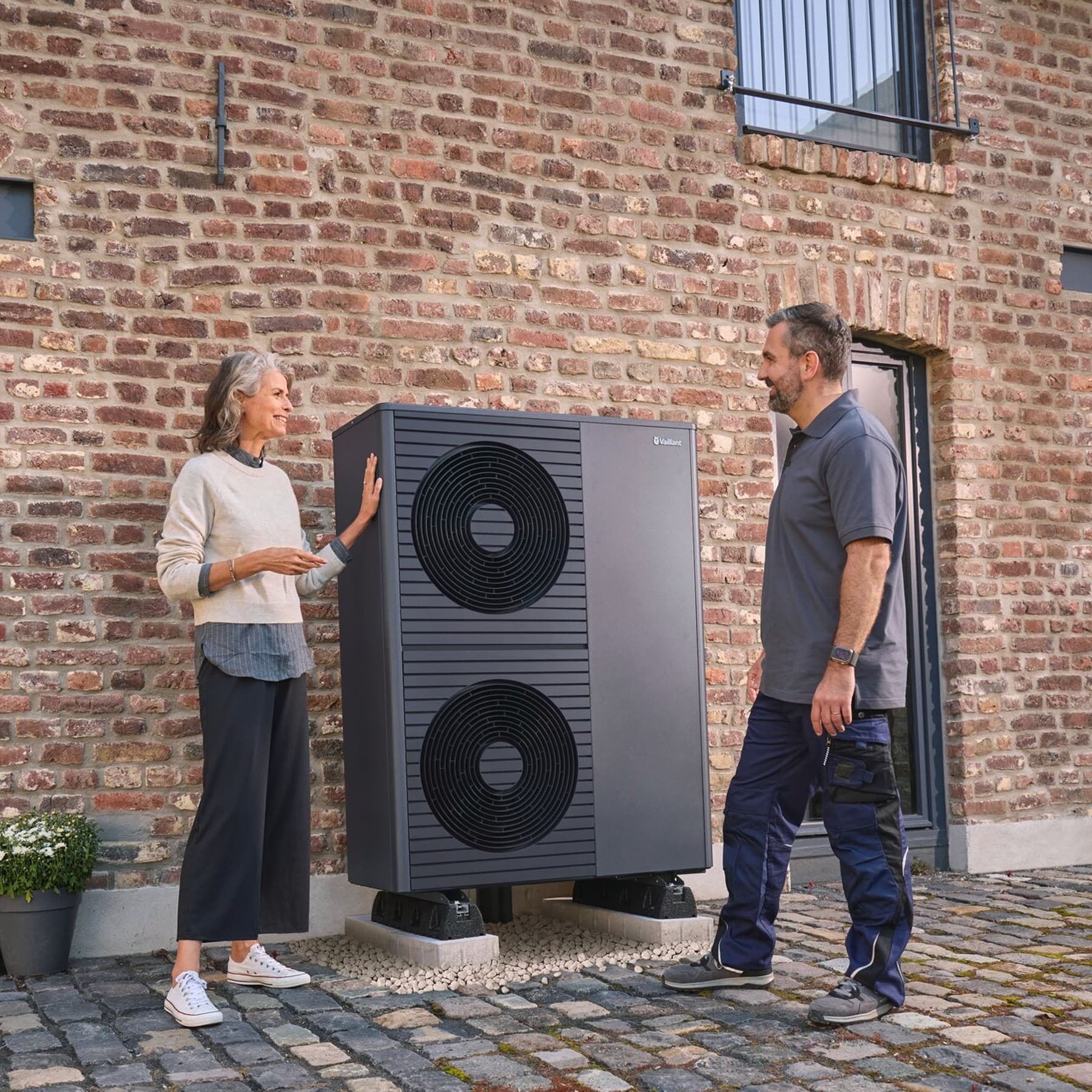 Ein Vaillant Stromspeicher auf Holzboden vor einer dunkelgrünen Wand.
