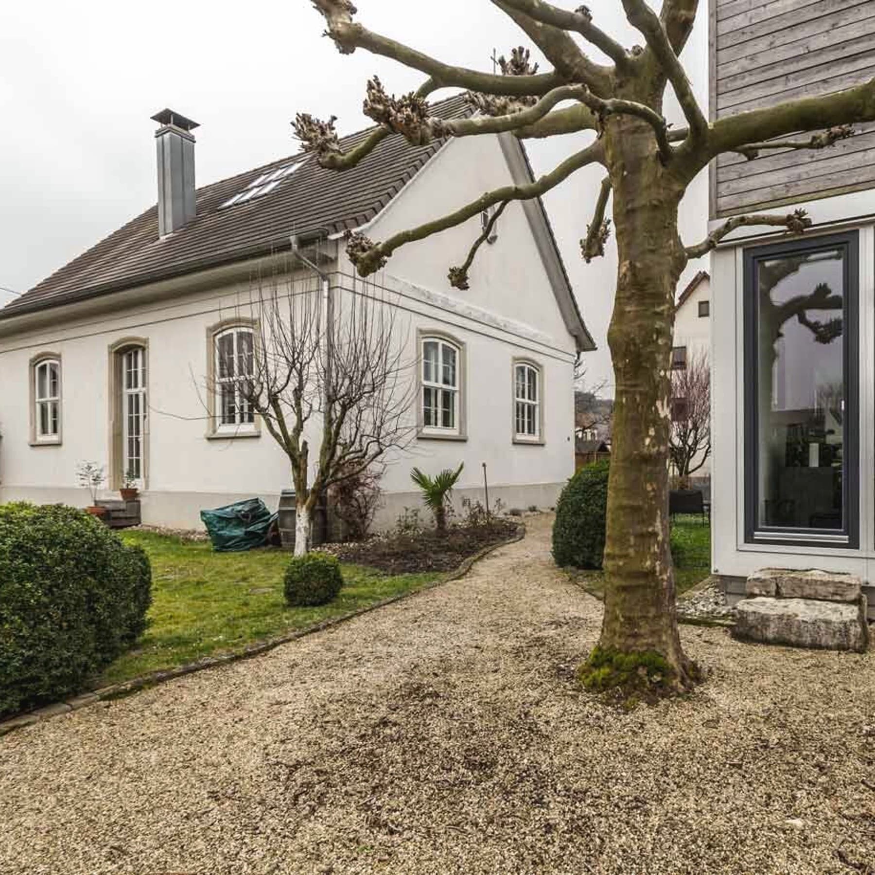 Frontansicht des alten Gemeindehauses auf der linken Seite und des Büro-Anbaus auf der rechten Seite